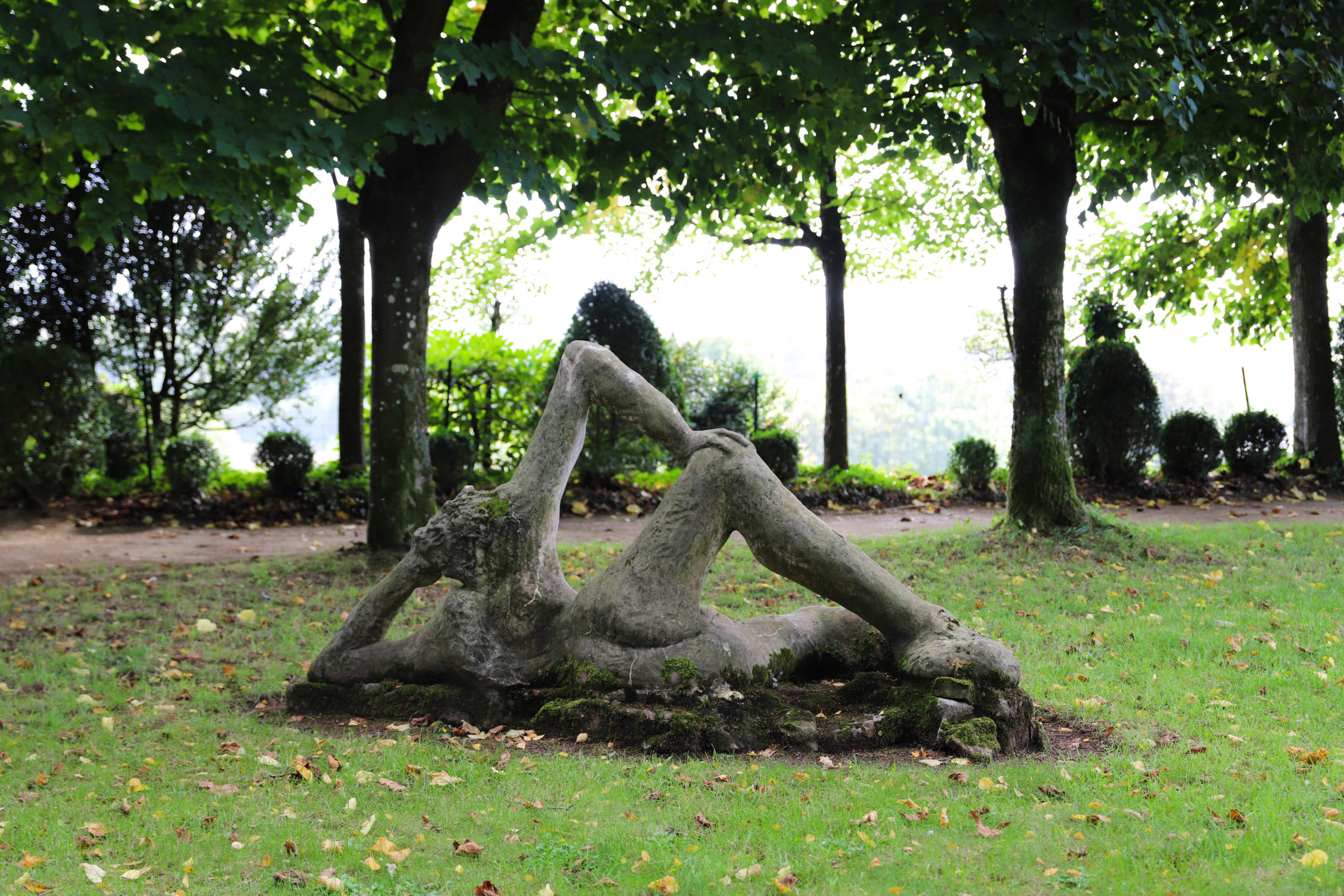 sculpture de femme nue au milieu du jardin
