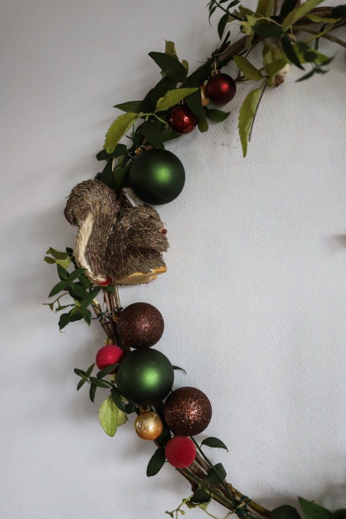 couronne de Noël réalisée avec des tiges de clématites et des boules de Noël