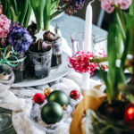 jacinthes colorées placées au centre de la table avec des bougies et des boules de Noël