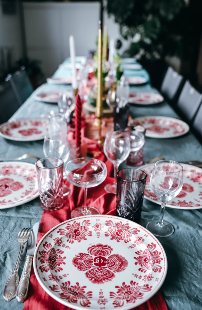 table de réveillon de Nouvel an avec de jolies assiettes vintage  et un centre de table dans les tons roses