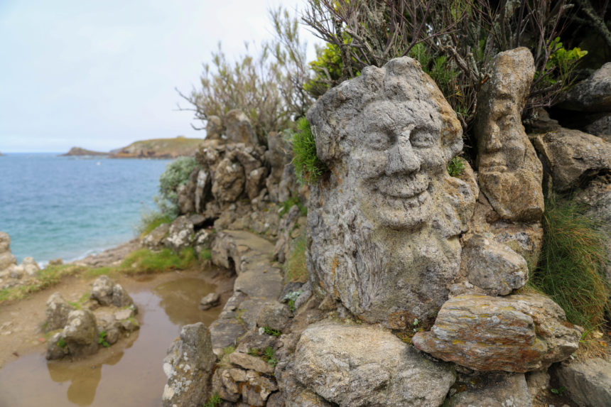 visage sculpté dans la pierre au bord de la mer en Bretagne