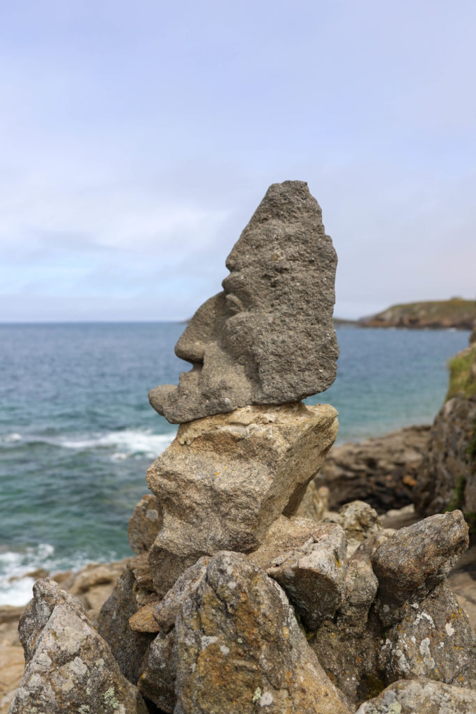 visage de profil sculpté dans un rocher face à la mer