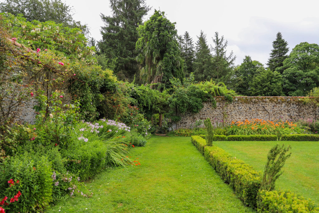 jardin luxuriant entouré de murs de pierres
