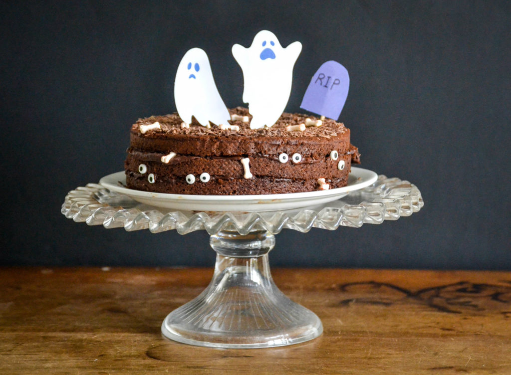 gâteau au chocolat pour Halloween décoré avec des fantômes, des yeux, des os en sucre