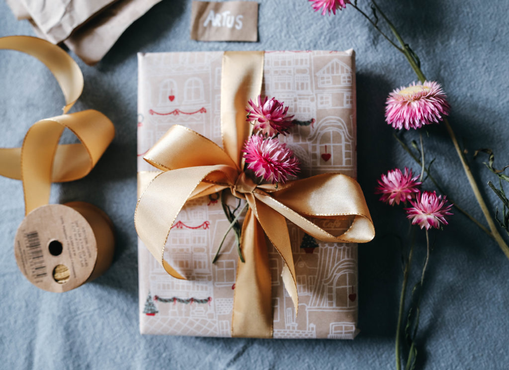 paquets cadeaux avec des fleurs séchées roses et un ruban doré