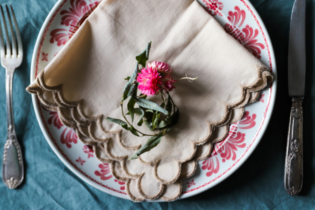 mini couronne de fleurs séchées posées sur une serviette au centre d'une assiette