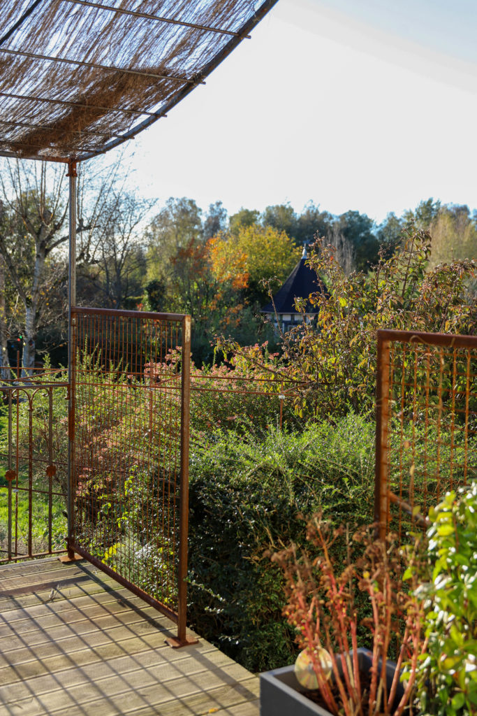 terrasse avec des treillis en fer fixés dessus afin de faire pousser des plantes