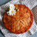 gâteau aux poires caramélisées doré avec une fleur comestible blanche sur le dessus pour décorer